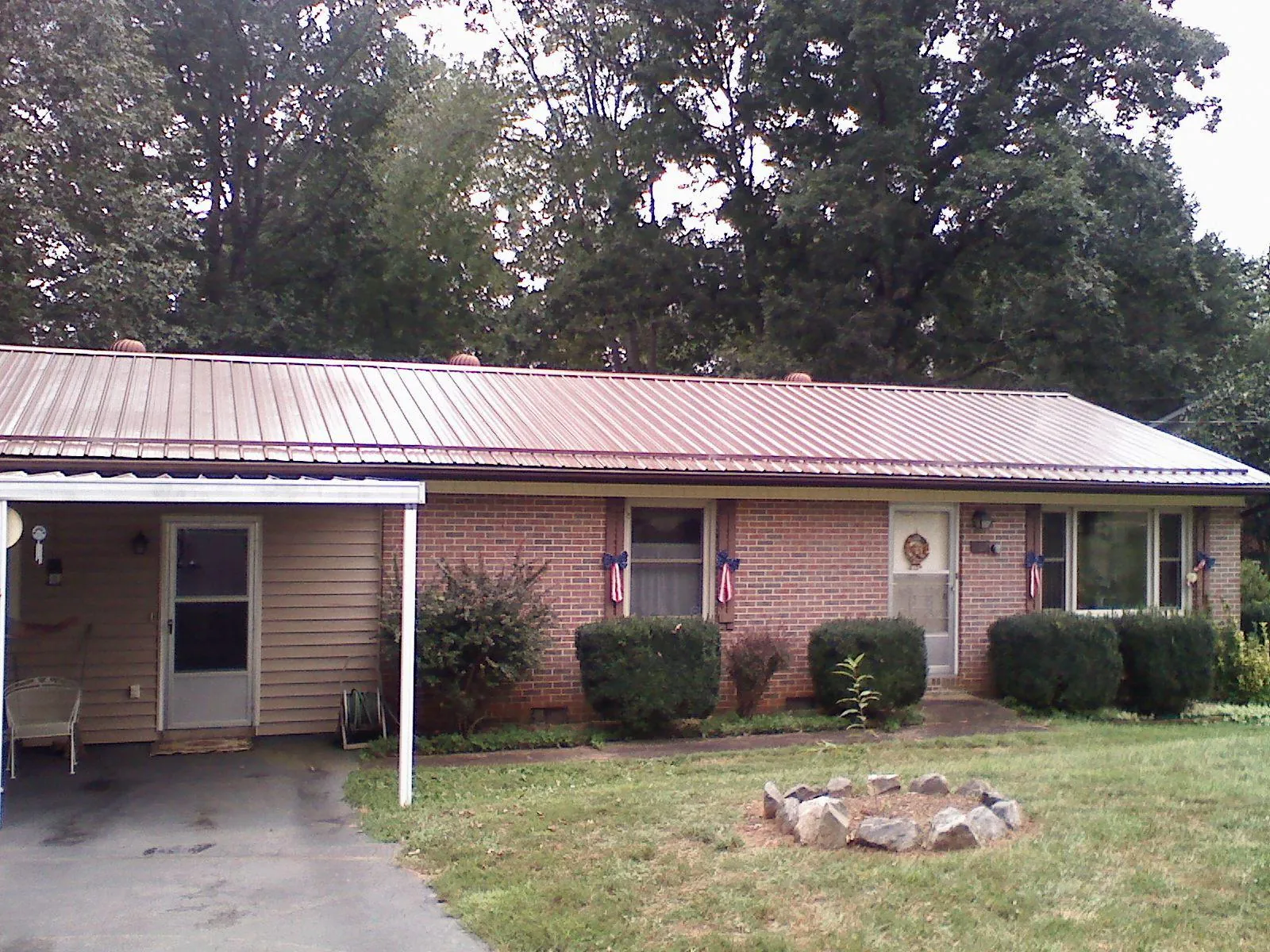 Bronze metal roof and carport on a brick ranch home — Roof Repair work by our crew in Castle Creek